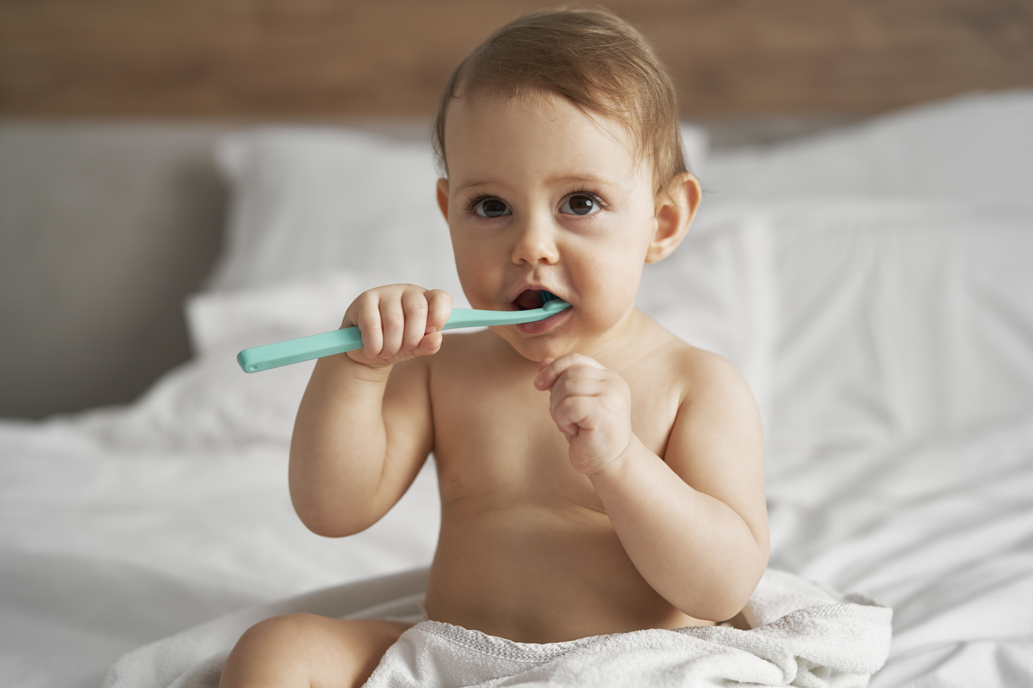 Little baby starting brushing a teeth after the bath